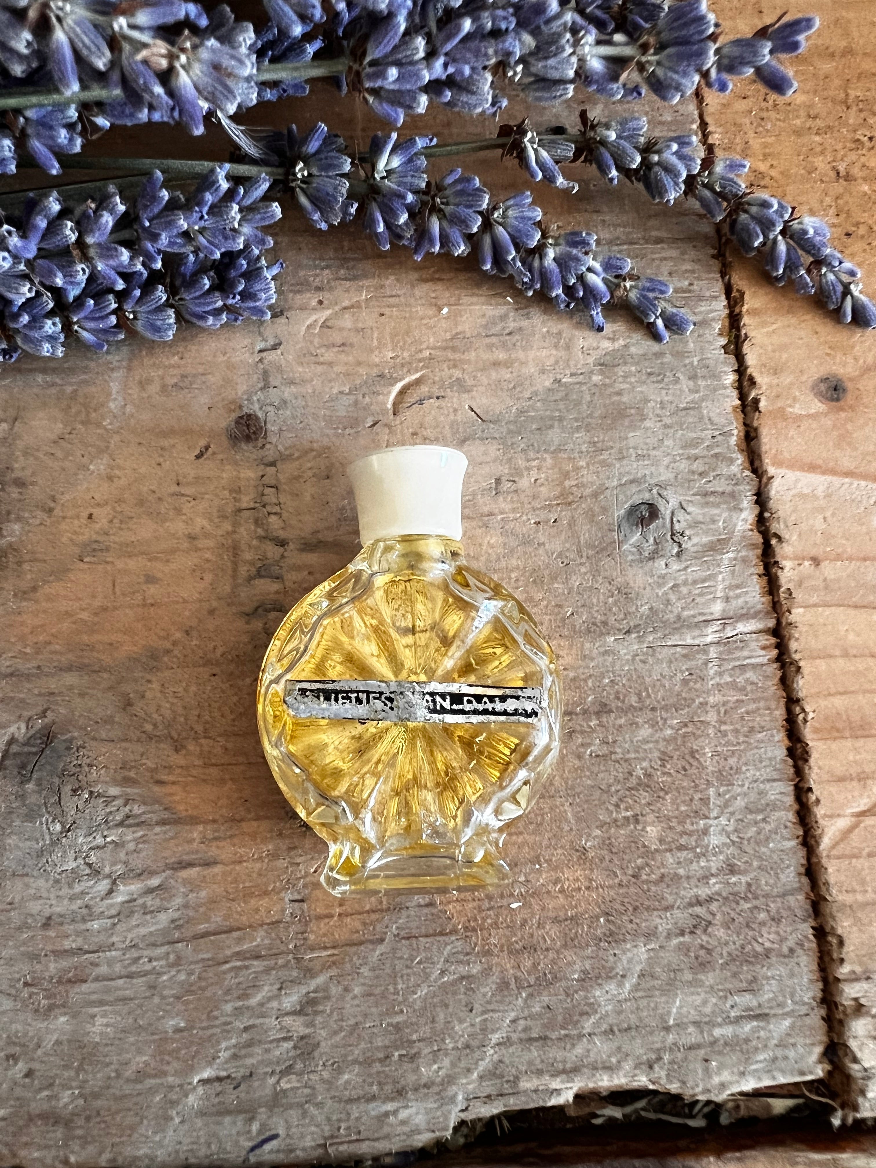 vintage miniatuur parfumflesje met een handgeborduurd bloemmotief van seringen in paarstinten