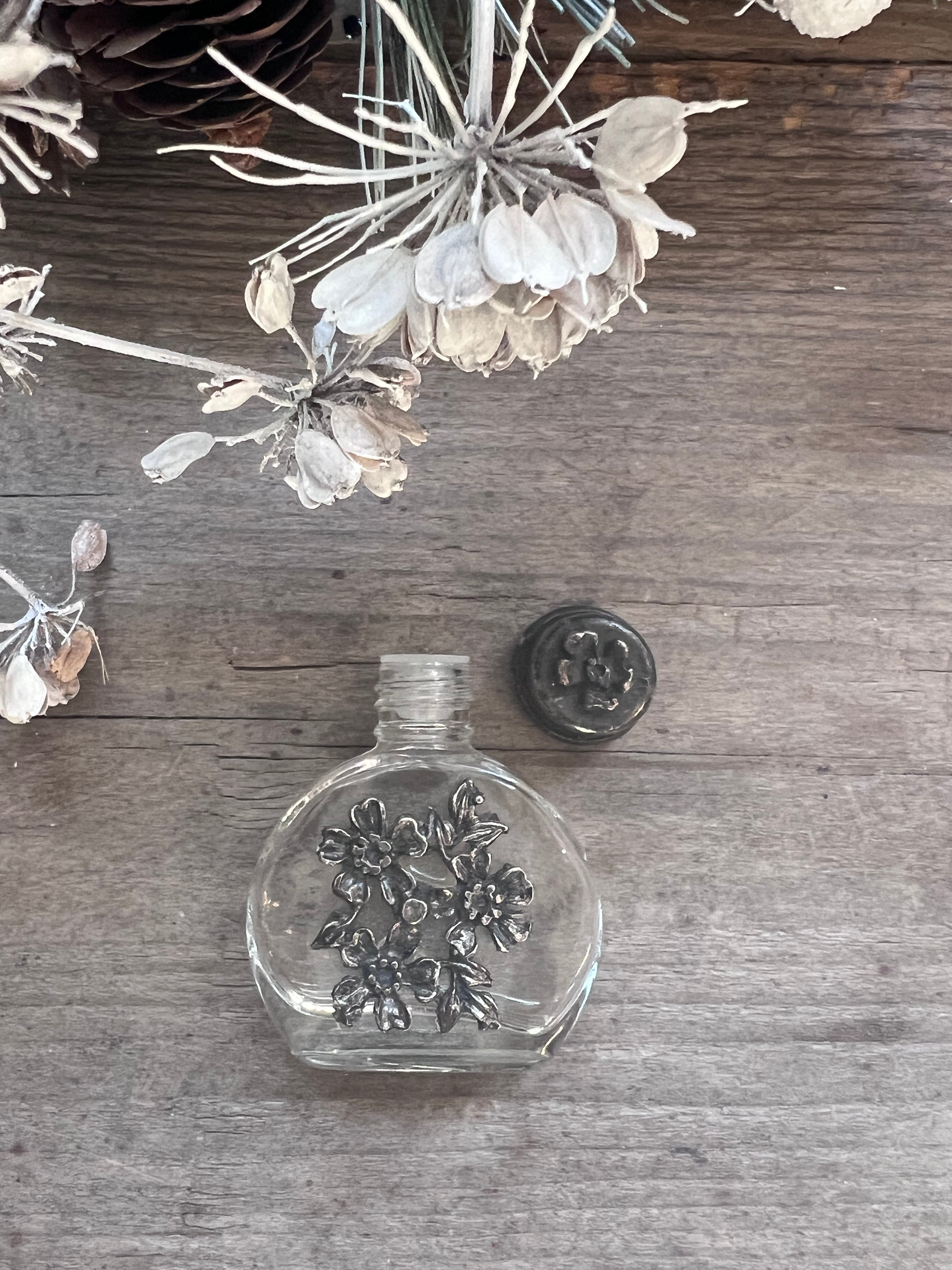 vintage parfumflesje glas, parfumflesje tinnen dop, vintage parfumflesje bloemenmandje, decoratief parfumflesje, vintage verzamelobject, parfumflesje collectors item, nostalgisch parfumflesje