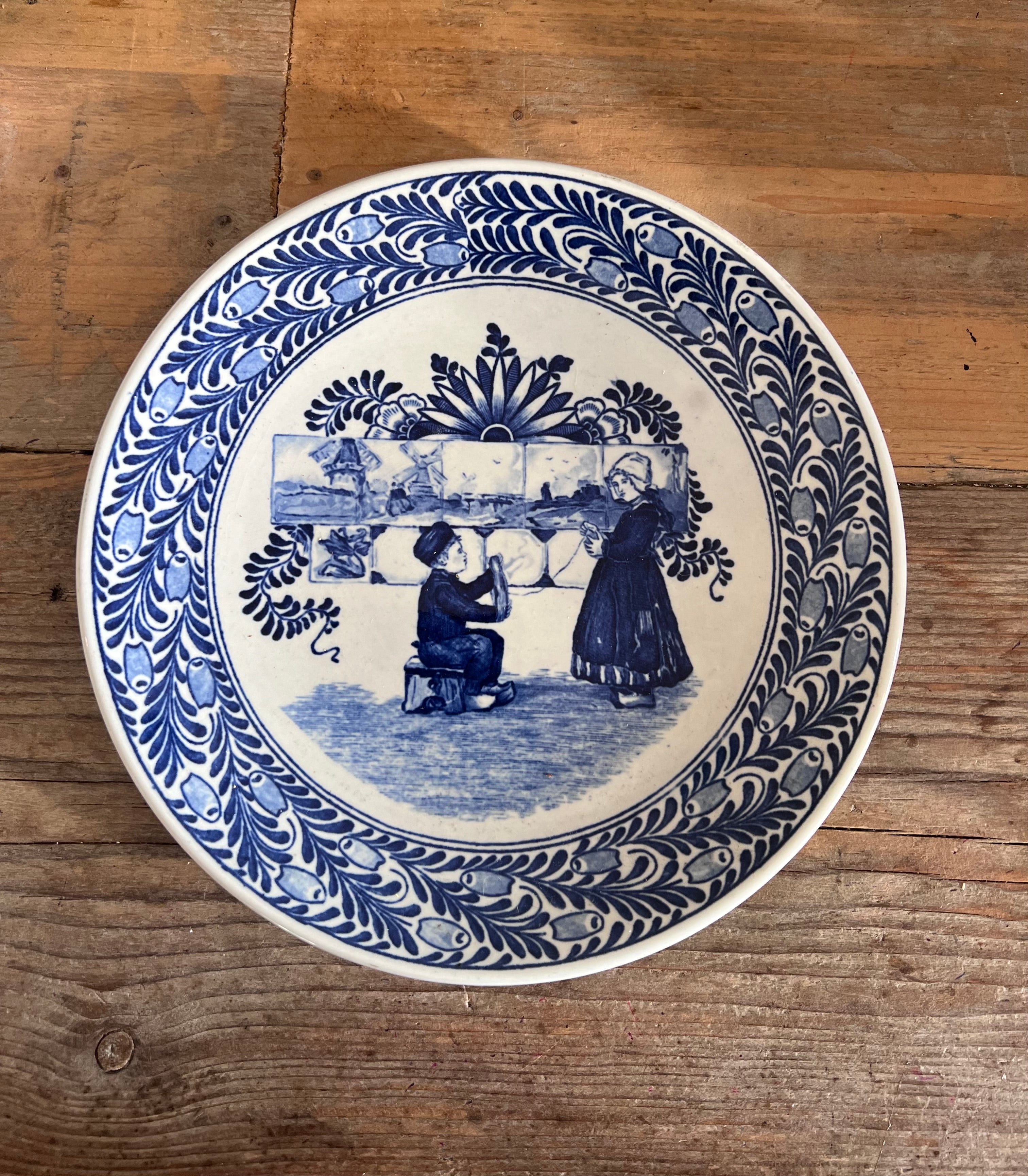 antiek wandbord Petrus Regout, Petrus Regout Fantasie serie, oud Hollands wandbord, blauw wit wandbord, Delfts blauw wandbord, wandbord boer en boerinnetje, vintage keramisch wandbord, Hollandse klederdracht bord, antiek decoratief bord, wanddecoratie vintage keramiek.