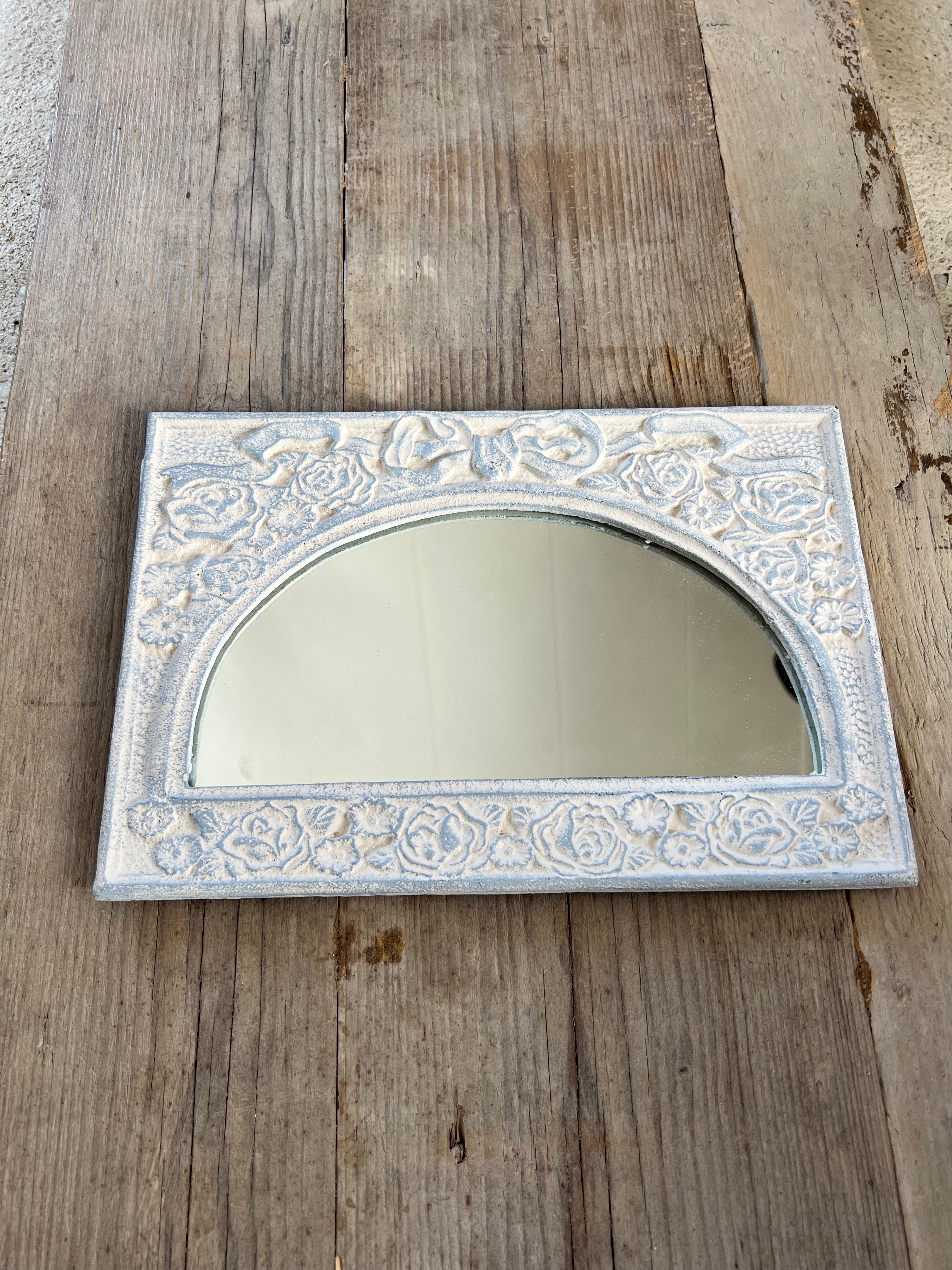 Vintage spiegel met gietijzeren omlijsting met strik en bloemen