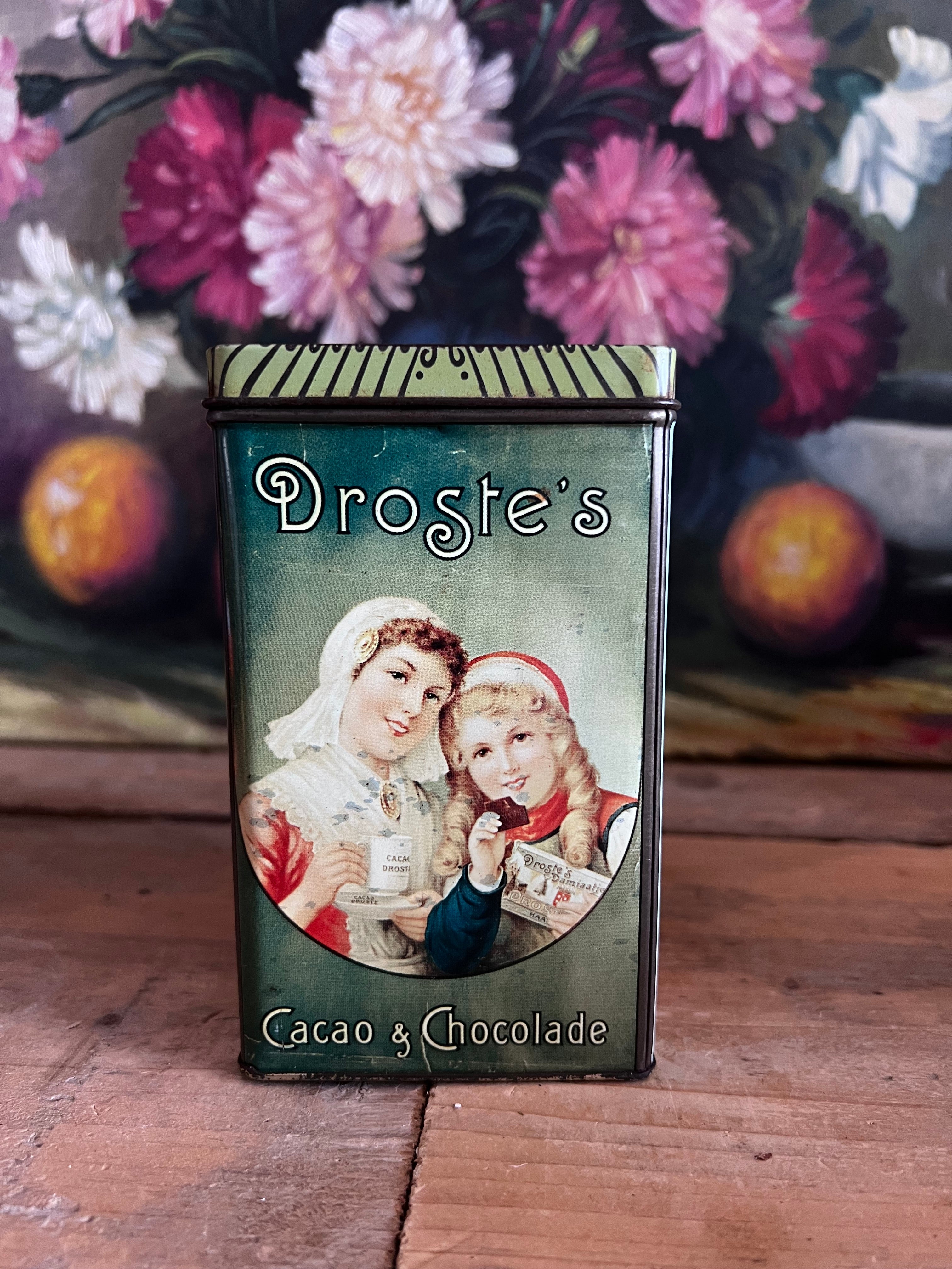 vintage Droste blik, Droste cacaopoeder blik, retro cacao verpakking, vintage blik met afbeelding, Droste moeder en dochter, decoratief blik cacao, nostalgisch cacao blik, metaal blik Droste, Droste cacaopoeder packaging, vintage keukendecor.