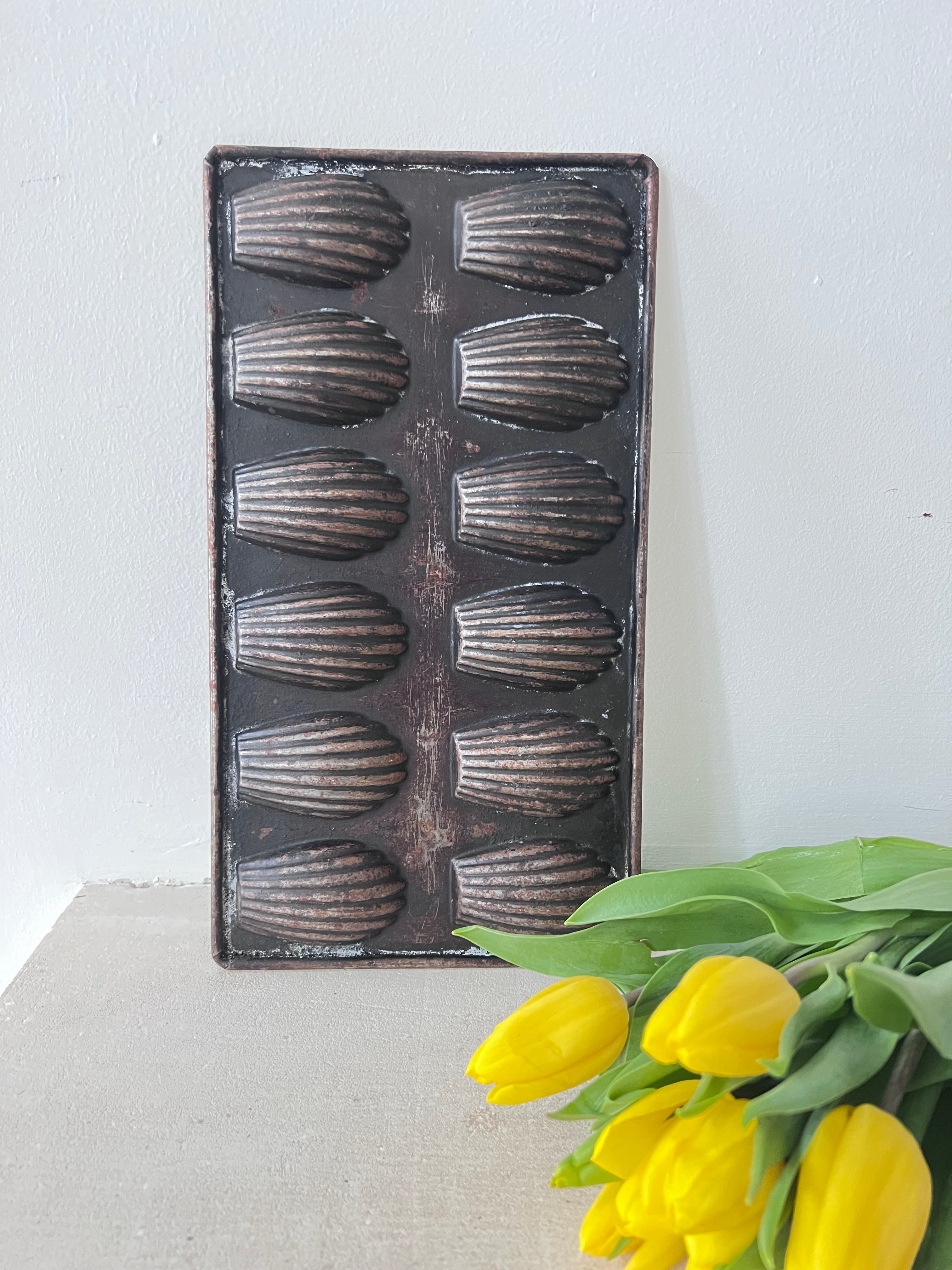 vintage madeleine bakvorm, Franse madeleine bakvorm, authentieke madeleine vorm, retro bakvorm Frankrijk, klassieke madeleine vorm, nostalgisch keukengerei, madeleine koekjes bakvorm, metalen madeleine vorm, traditionele Franse bakvorm, vintage bakvorm voor madeleines.