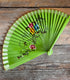 Groene handbeschilderde waaier met bloemen. hout