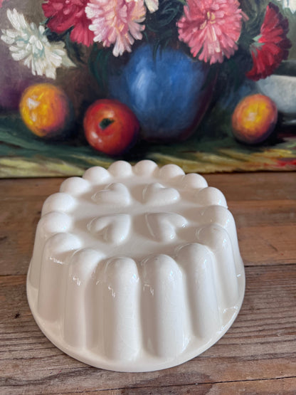 vintage puddingvorm, puddingvorm aardewerk, puddingvorm hartjes, beige puddingvorm, retro bakvorm, aardewerk bakvorm, decoratieve puddingvorm, traditionele puddingvorm, nostalgische keukendecoratie, vintage keukengerei.