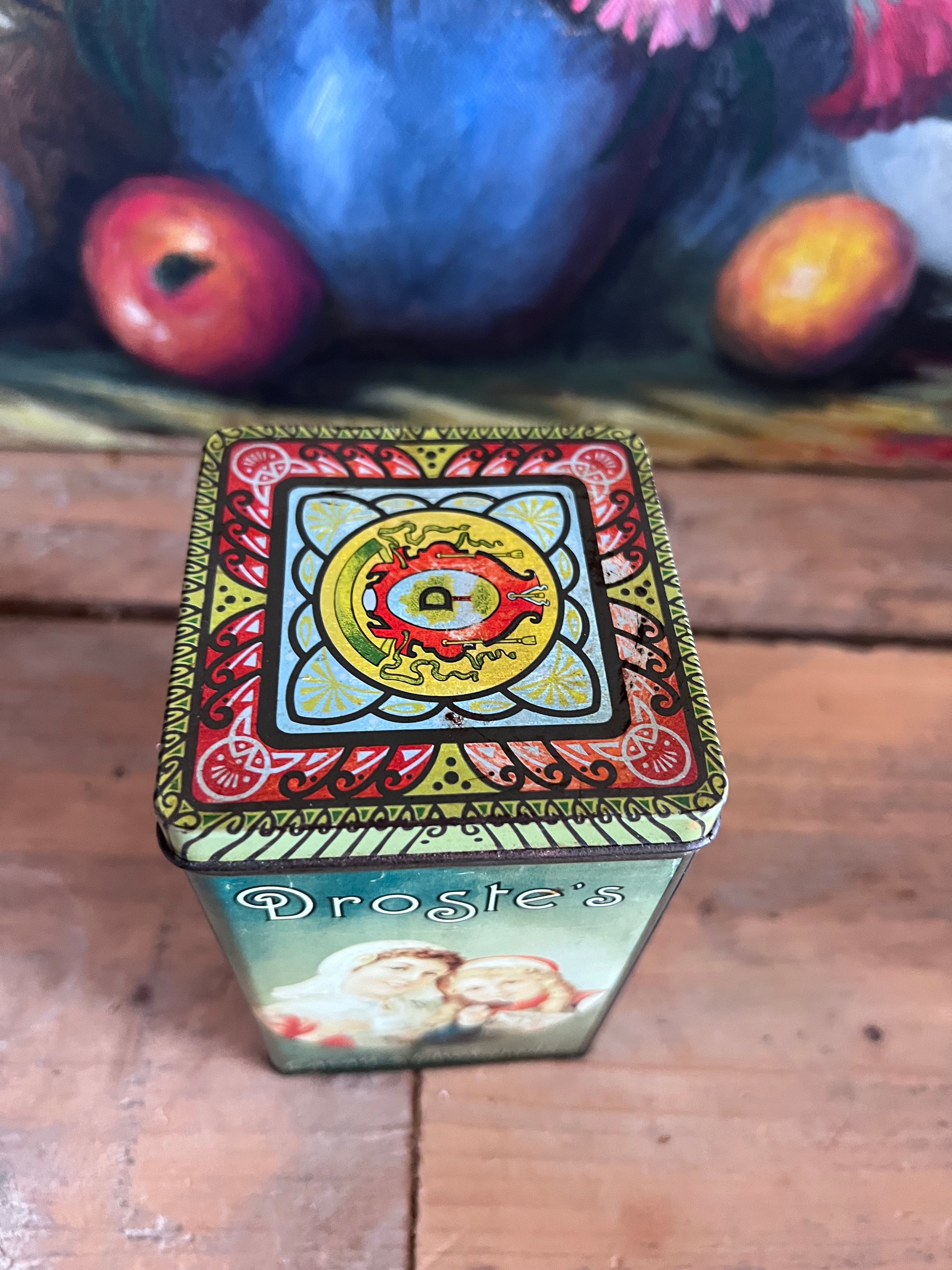 vintage Droste blik, Droste cacaopoeder blik, retro cacao verpakking, vintage blik met afbeelding, Droste moeder en dochter, decoratief blik cacao, nostalgisch cacao blik, metaal blik Droste, Droste cacaopoeder packaging, vintage keukendecor.