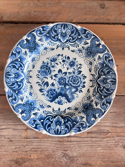 Dit prachtig handbeschilderde wandbord is afkomstig uit de wereldberoemde fabriek uit Delft, de Porceleyne Fles en toont een klassiek boeket in vaas. Het bord staat symbool voor traditioneel Nederlands vakmanschap en is een waardevol decoratief kunstwerk voor aan de muur.&amp;nbsp;

Perfect voor liefhebbers van Delftsblauw en authentieke porseleinen wanddecoratie.&amp;nbsp;

Diameter 28 centimeter