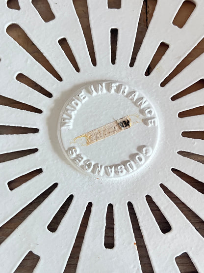 vintage Le Creuset onderzetter, Cousances gietijzeren onderzetter, geëmailleerde onderzetter wit, Franse Le Creuset accessoires, gietijzeren onderzetter vintage, Le Creuset keukenaccessoires, ronde onderzetter gietijzer, duurzame onderzetter, Le Creuset Cousances vintage, hittebestendige onderzetter