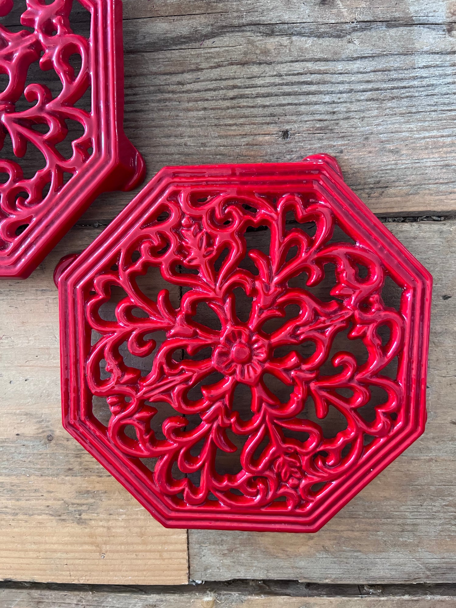 rode onderzetter gietijzer, vintage onderzetter pannen, gietijzeren onderzetter retro, onderzetter voor hete pannen, vintage keukenaccessoires, gietijzeren pannendrager, retro pannenonderzetter, keukendecor vintage.