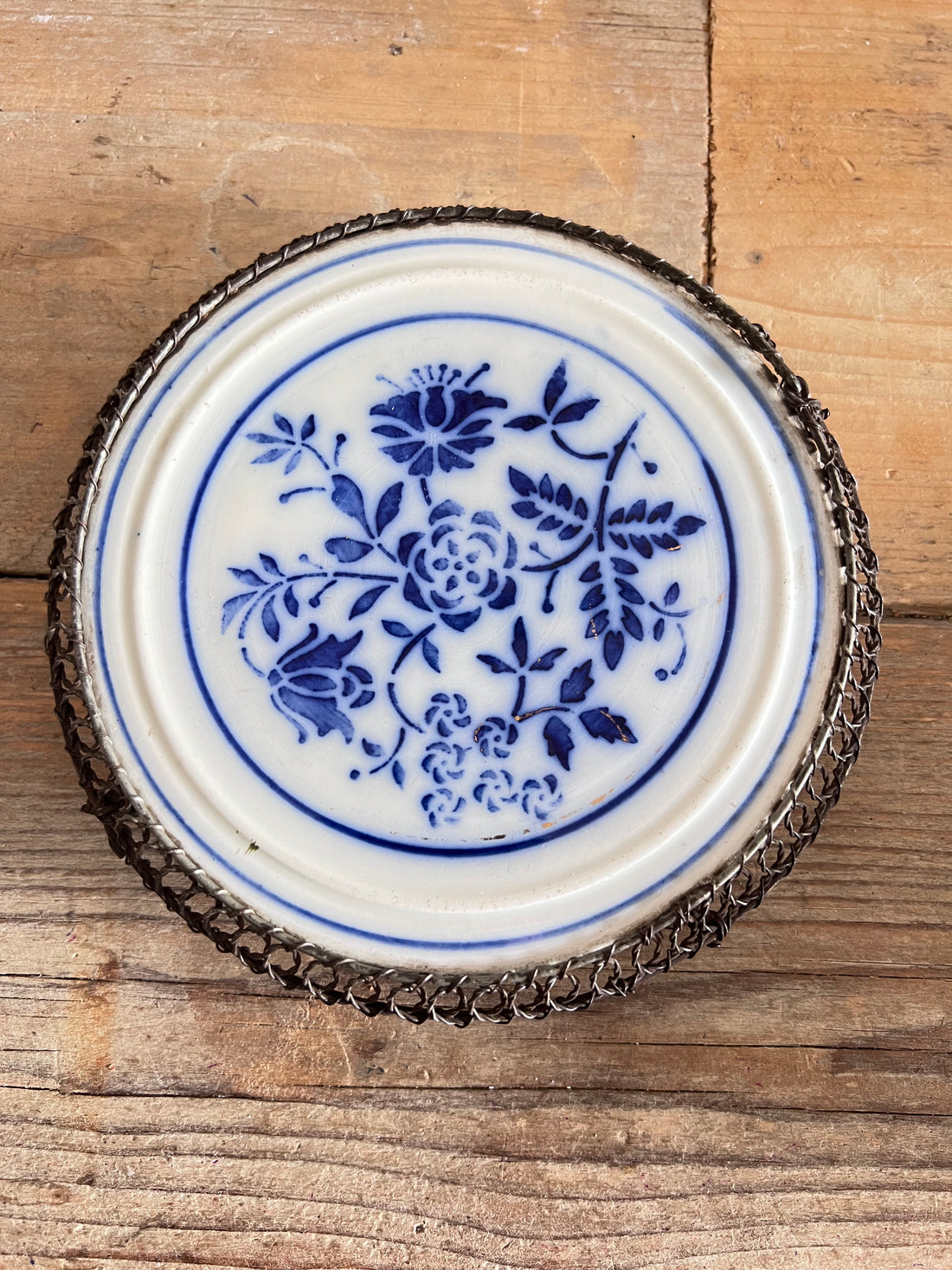 vintage onderzetter porselein, onderzetter blauw wit, vintage tafelaccessoires, jaren 30 onderzetter, vintage bloemmotief, porseleinen onderzetter kannen, antieke onderzetters, retro keukendecoratie.