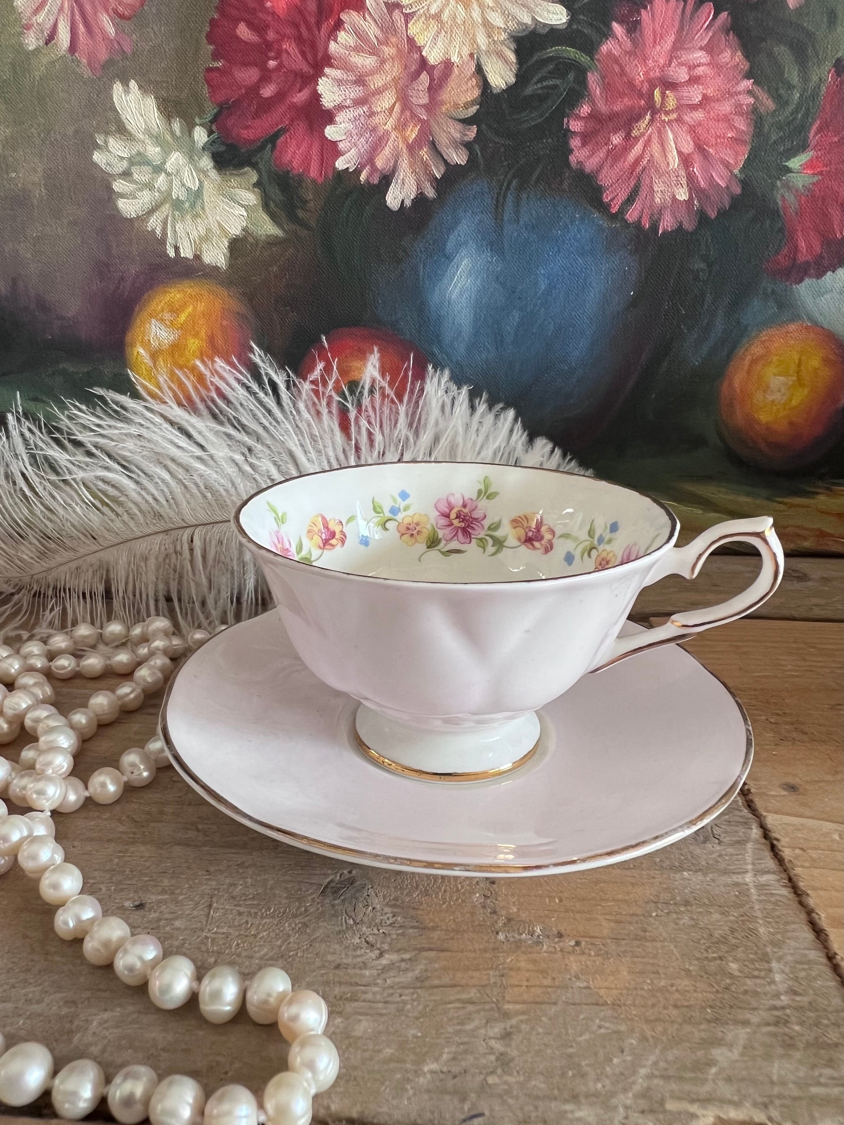 roze kop en schotel, Springfield porselein, kop en schotel met bloemen, porseleinen theekopje, vintage roze servies, kopje met bloemenprint, elegant porselein, theeservies roze, Bloemmotief porselein.