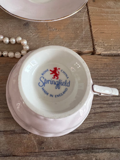 roze kop en schotel, Springfield porselein, kop en schotel met bloemen, porseleinen theekopje, vintage roze servies, kopje met bloemenprint, elegant porselein, theeservies roze, Bloemmotief porselein.