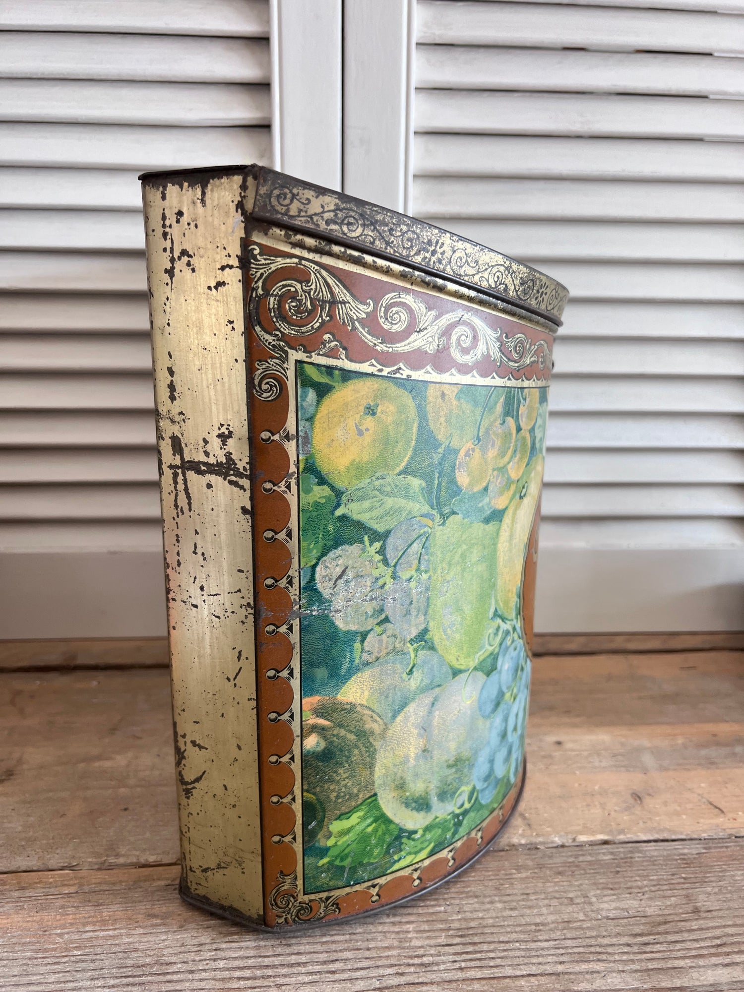 vintage Van Melle toffeeblik, antiek toffeeblik, Van Melle snoepblik, half cilindrisch blik, fruitdecoratie blik, toffeeblik met scharnierdeksel, retro snoepblik, vintage snoepblik, antieke snoepverpakking, collectible toffeeblik, snoepblik uit 1915-1930
