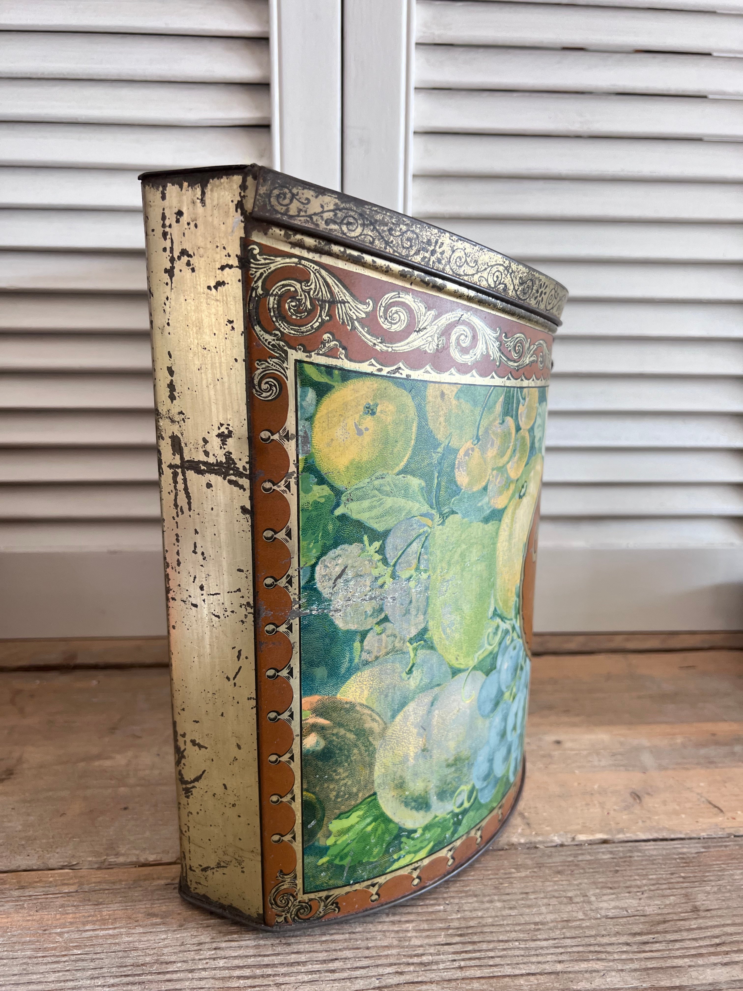 vintage Van Melle toffeeblik, antiek toffeeblik, Van Melle snoepblik, half cilindrisch blik, fruitdecoratie blik, toffeeblik met scharnierdeksel, retro snoepblik, vintage snoepblik, antieke snoepverpakking, collectible toffeeblik, snoepblik uit 1915-1930